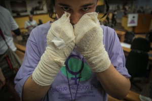 Na foto, Luisa Gabriela com as mãos atadas em alusão à jovem que teve as mãos cortadas pelo companheiro